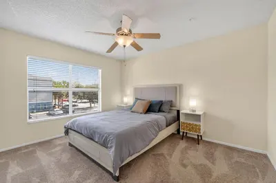 a bedroom with a bed and a ceiling fan at Modern 2BR Stay in Prime Location in Orlando