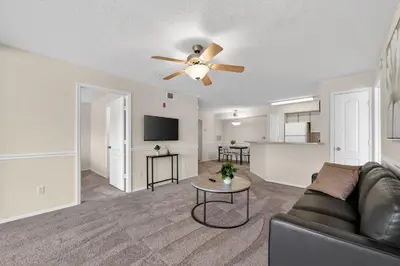 a living room with a couch and a ceiling fan at Modern 2BR Stay in Prime Location in Orlando