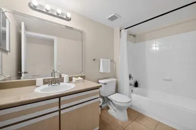 a bathroom with a sink and a toilet and a mirror at Modern 2BR Stay in Prime Location in Orlando