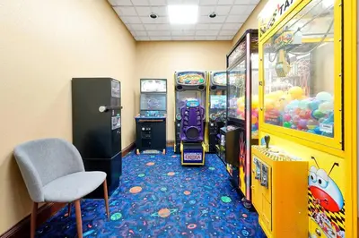 a room with two arcade games and a chair at Free Shuttle Mickey Universal Epic SeaWorld in Orlando