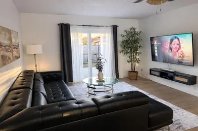 a living room with a leather couch and a glass table at Family Retreat - 9 Min from Disney in Kissimmee