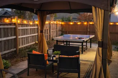 a ping pong table and chairs under an umbrella at Family Retreat - 9 Min from Disney in Kissimmee