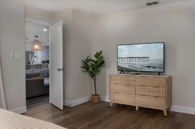 a living room with a flat screen tv on a dresser at Spacious home w screened patio & EV charger in Orlando