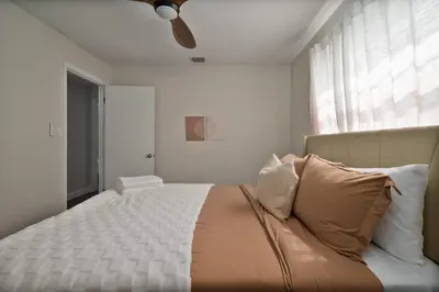 a bedroom with a large bed with a ceiling fan at Spacious home w screened patio & EV charger in Orlando