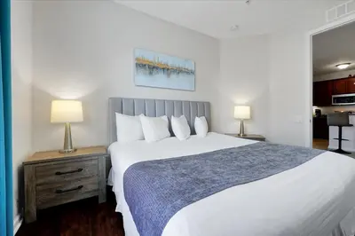 a bedroom with a large white bed with two lamps at Epic Universe Condo - Vista Cay - 2028 in Orlando