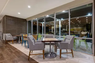 a dining room with chairs and a table and windows at Home2 Suites by Hilton Orlando International Drive South - Free Shuttle to Theme Parks in Orlando