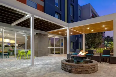 a patio with a fire pit in front of a building at Home2 Suites by Hilton Orlando International Drive South - Free Shuttle to Theme Parks in Orlando