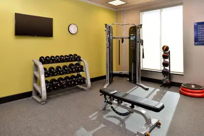 a gym with dumbbells and a tv on a wall at Hampton Inn & Suites Orlando/Downtown South - Medical Center in Orlando