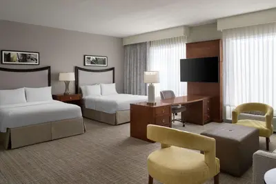a hotel room with two beds and a desk at Hampton Inn & Suites Orlando/Downtown South - Medical Center in Orlando
