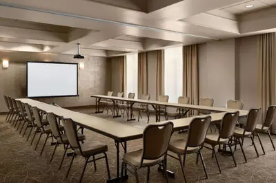 a conference room with tables and chairs and a screen at Hampton Inn & Suites Orlando/Downtown South - Medical Center in Orlando