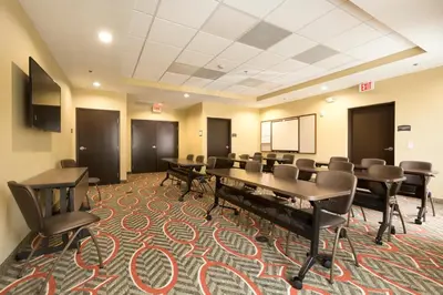 a conference room with tables and chairs and a chalkboard at Staybridge Suites Orlando at SeaWorld by IHG - Free Breakfast & Shuttle to SeaWorld Parks in Orlando
