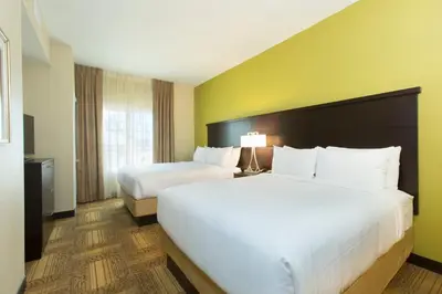 a hotel room with two beds and a window at Staybridge Suites Orlando at SeaWorld by IHG - Free Breakfast & Shuttle to SeaWorld Parks in Orlando