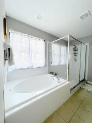 a white bath tub in a bathroom with a window at Clermont Vacation Homes by DWS Vacation in Orlando