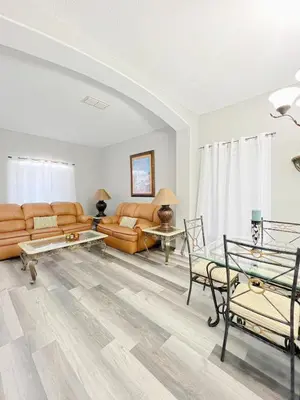 a living room with couches and a table at Clermont Vacation Homes by DWS Vacation in Orlando