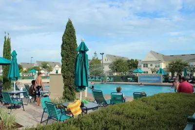a pool at a resort with chairs and umbrellas at True Happiness, Housing Near Disney Word in Kissimmee