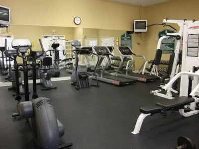 a gym with several tread machines and a clock at True Happiness, Housing Near Disney Word in Kissimmee