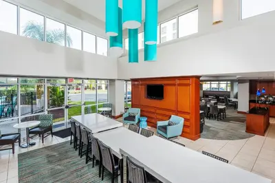 a large lobby with a bar and tables and chairs at Residence Inn Orlando Airport in Orlando