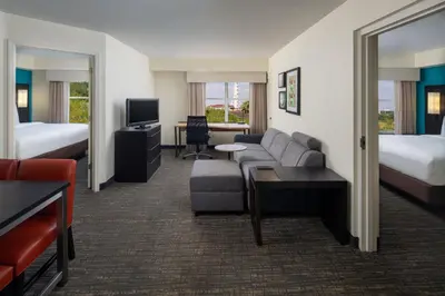 a hotel room with a couch and a bed at Residence Inn Orlando Convention Center in Orlando