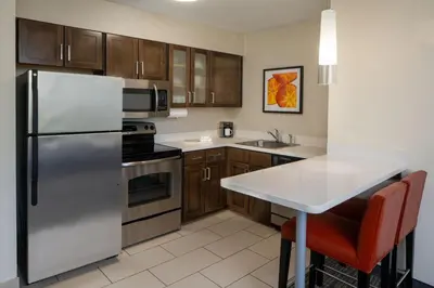 a kitchen with a stainless steel refrigerator and a table at Residence Inn Orlando Convention Center in Orlando