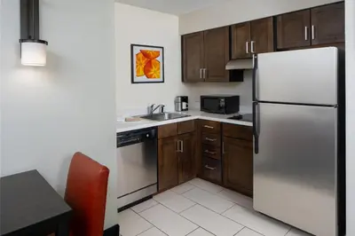 a kitchen with a stainless steel refrigerator and wooden cabinets at Residence Inn Orlando Convention Center in Orlando
