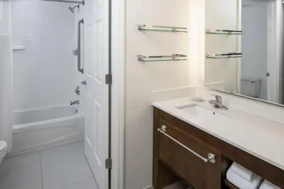 a bathroom with a sink and a mirror and a tub at Residence Inn Orlando Convention Center in Orlando
