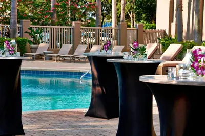 a group of tables and chairs next to a pool at Renaissance Orlando Airport Hotel in Orlando
