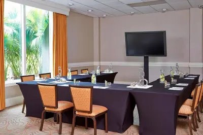 a conference room with a table with chairs and a tv at Renaissance Orlando Airport Hotel in Orlando