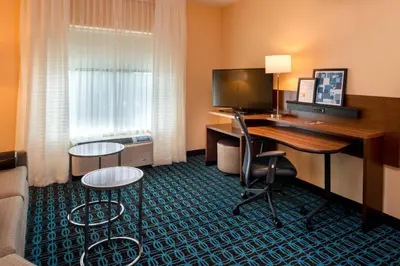 a hotel room with a desk with a computer in it at Fairfield Inn & Suites by Marriott Orlando East/UCF Area in Orlando