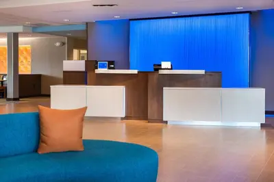 a lobby with a couch and a reception desk at Fairfield Inn & Suites by Marriott Orlando East/UCF Area in Orlando