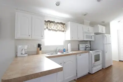 a kitchen with white cabinets and a white refrigerator at Sherwood Forest Cottage 6 in Kissimmee
