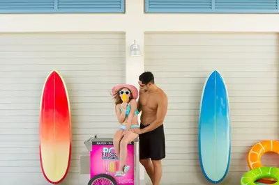 a man and a woman standing next to surfboards at The Grove Resort & Water Park Orlando in Orlando