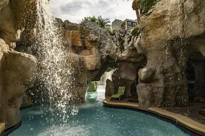 a waterfall in a swimming pool in a resort at Hyatt Regency Grand Cypress Resort - Free Shuttle to Theme Parks! in Orlando