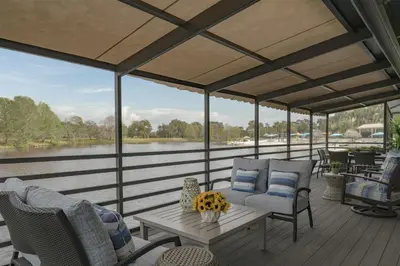 a screened porch with chairs and a table and a lake at Hyatt Regency Grand Cypress Resort - Free Shuttle to Theme Parks! in Orlando