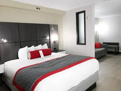 a bedroom with a large bed and a couch at Ramada by Wyndham Suites Orlando Airport- Free Airport Shuttle in Orlando