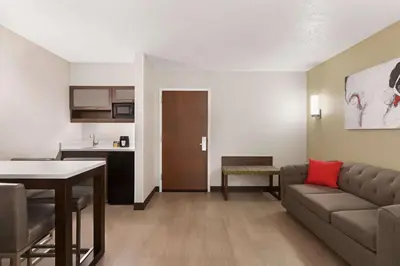a living room with a couch and a table at Ramada by Wyndham Suites Orlando Airport- Free Airport Shuttle in Orlando