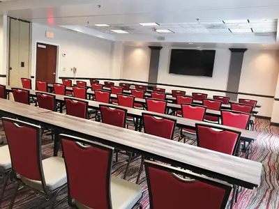 a conference room with red chairs and a table at Ramada by Wyndham Suites Orlando Airport- Free Airport Shuttle in Orlando