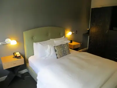 a bedroom with a large bed with white sheets and pillows at The EO Inn - Downtown Orlando in Orlando