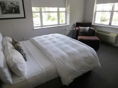 a bedroom with a large white bed and a chair at The EO Inn - Downtown Orlando in Orlando