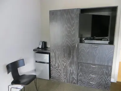 a metal wall with a tv and a chair in a room at The EO Inn - Downtown Orlando in Orlando