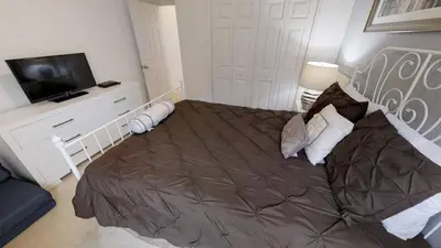 a bedroom with a large bed and a flat screen tv at Crystal Cove 4 Bedroom Vacation Home 1527 in Kissimmee