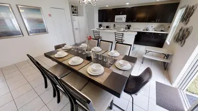 a dining room with a table and chairs and a kitchen at Crystal Cove 4 Bedroom Vacation Home 1527 in Kissimmee