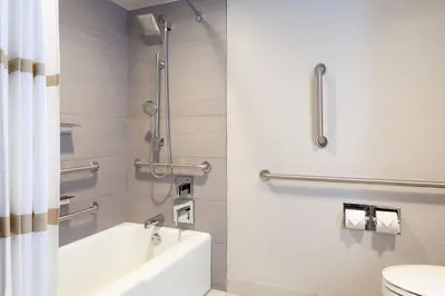 a bathroom with a shower and a tub and a toilet at Marriott Orlando Airport Lakeside in Orlando