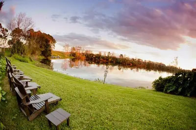 a row of wooden benches sitting next to a lake at Marriott Orlando Airport Lakeside in Orlando