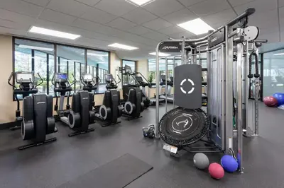 a gym with a row of treadmills and machines at Marriott Orlando Airport Lakeside in Orlando