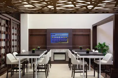 a dining room with tables and chairs and a tv at Marriott Orlando Airport Lakeside in Orlando