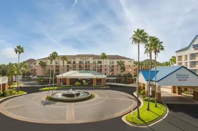 a rendering of a hotel with a fountain and palm trees at Fairfield Inn & Suites by Marriott Orlando Lake Buena Vista in the Marriott Village in Orlando