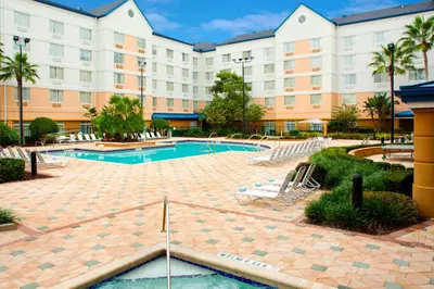 a hotel with a swimming pool and a building at Fairfield Inn & Suites by Marriott Orlando Lake Buena Vista in the Marriott Village in Orlando