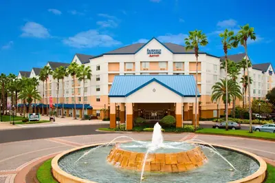 a fountain in front of a hotel with a building at Fairfield Inn & Suites by Marriott Orlando Lake Buena Vista in the Marriott Village in Orlando
