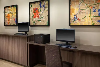 a desk with two monitors and a computer on it at Residence Inn by Marriott Orlando at SeaWorld in Orlando