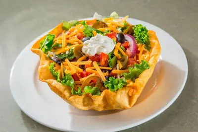 a sandwich with vegetables and cheese on a white plate at Residence Inn by Marriott Orlando at SeaWorld in Orlando